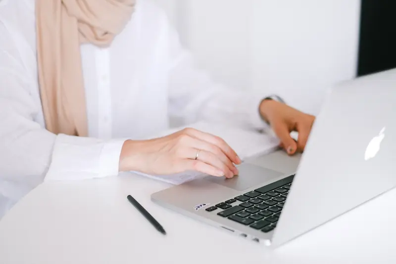 seorang wanita sedang bekerja di depan laptop