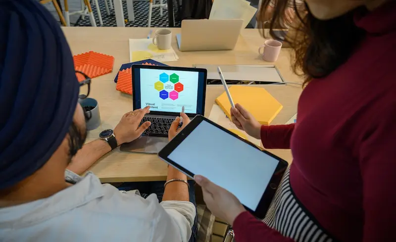 dua orang sedang berdiskusi di depan tablet