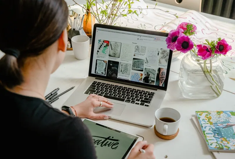 seorang wanita sedang mendesain di laptop