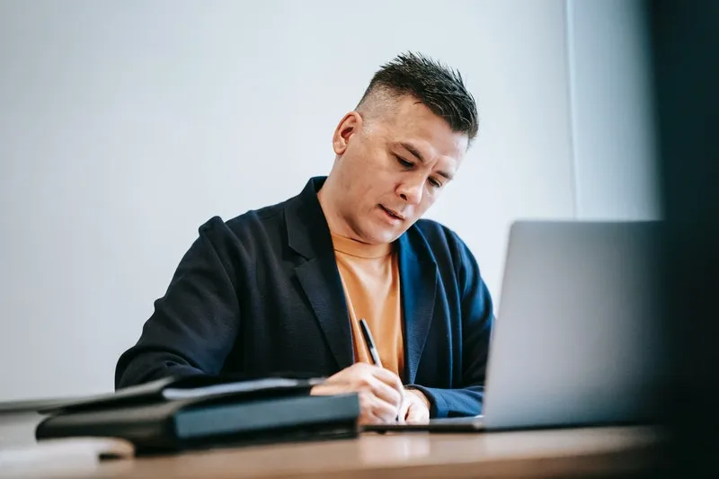 seorang pria sedang fokus bekerja di depan laptop