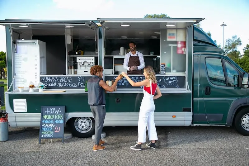 dua orang sedang membeli makanan dari food truck