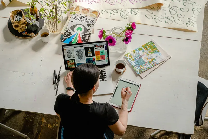 seorang wanita sedang mengerjakan proyek di depan laptop