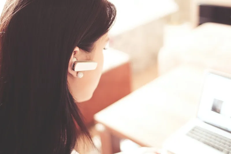 seorang wanita sedang mengenakan earphone putih