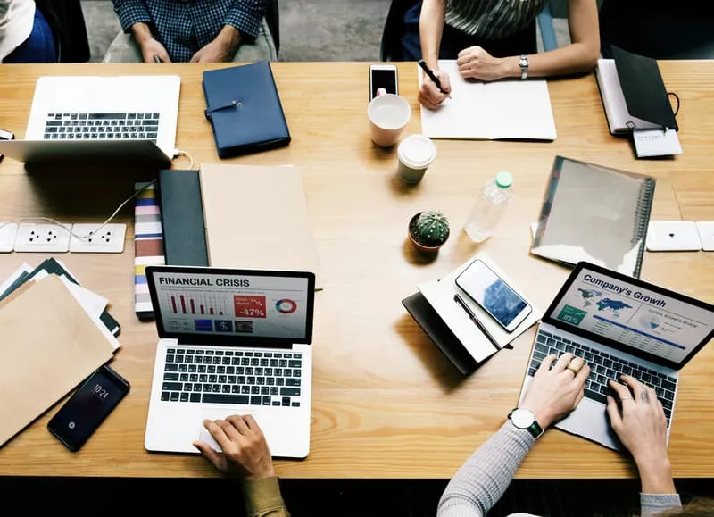 kumpulan orang sedang bekerja di depan laptop