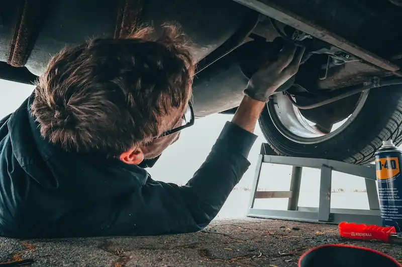 seseorang sedang memperbaiki mesin mobil