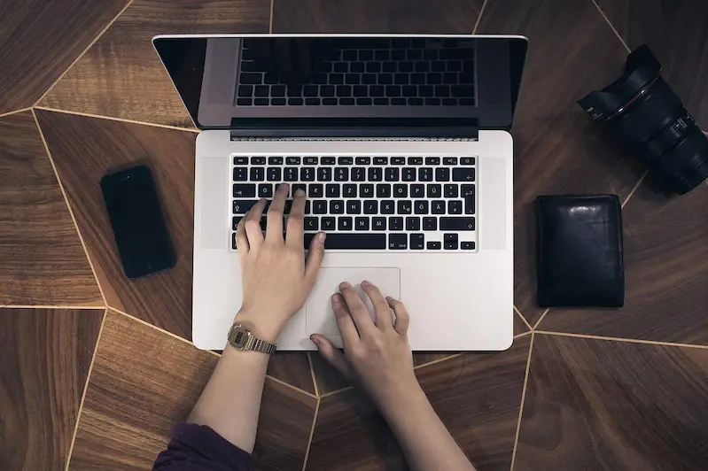 seseorang sedang mengetik di laptop