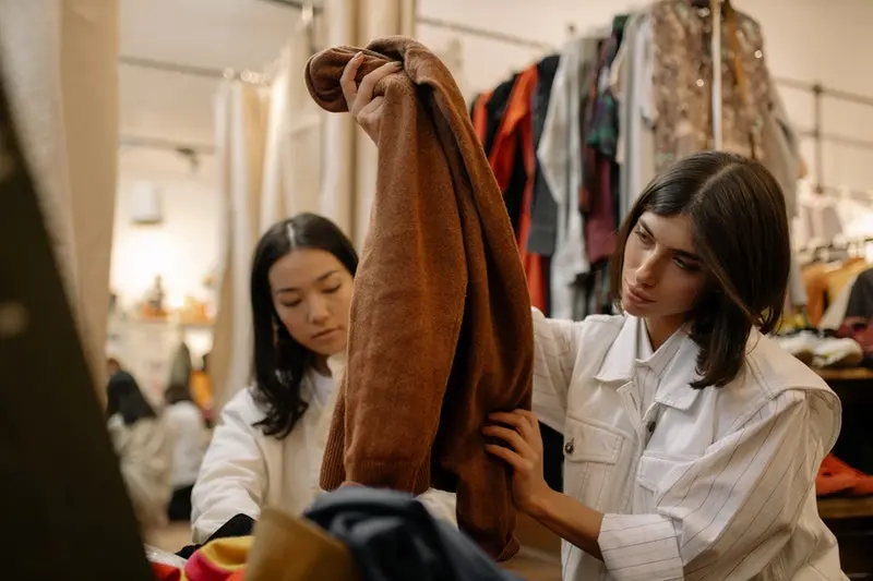 seorang wanita sedang berbelanja baju bekas